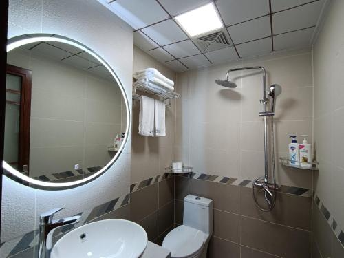 Un baño con inodoro, lavabo y espejo. en Wuling Spring Inn, Yongding District, Zhangjiajie City, 