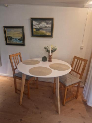 a dining room table with two chairs and a white table at Mælkevejens bnb in Skødstrup