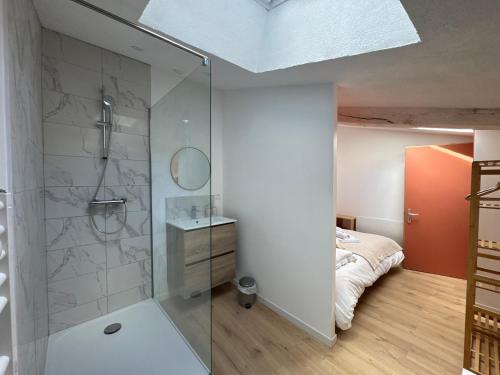 a bathroom with a glass shower and a bed at La Maison D'isaure 6 personnes Parthenay centre in Parthenay