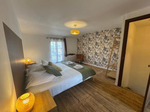 a bedroom with a bed with white sheets and pillows at La Maison D'isaure 6 personnes Parthenay centre in Parthenay