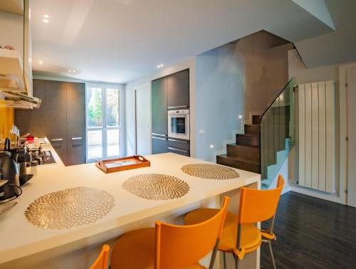 una cocina con mesa y sillas y una escalera en Luer Prince - Villetta con vista lago sul Lago Iseo, en Lovere