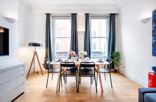 a dining room with a table and chairs at Welcome London Covent Garden Piazza in London
