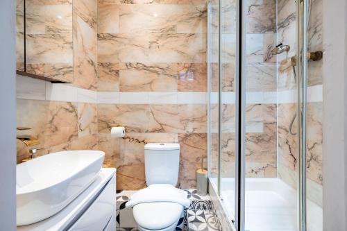 Un baño con inodoro, lavabo y ducha. en Welcome London Covent Garden Piazza, en Londres