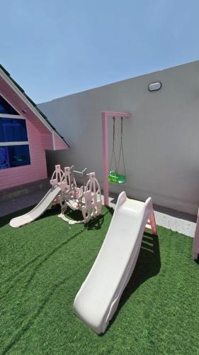 a play area with a slide and a playground at شاليهات روزڤيو الريفيه Roseview chalets in Taif