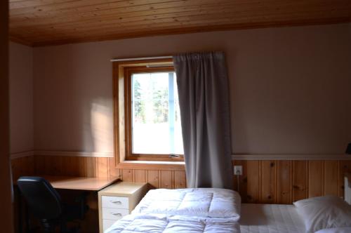 a bedroom with a bed and a window at Fulufjellet nationalpark Lodge - Fulufjellets national parks - This is the place where Norway and Sweden meet in a large protected area in Ljørdalen