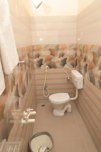a bathroom with a toilet with a mural of rats at Magesh Residency in Jāmb