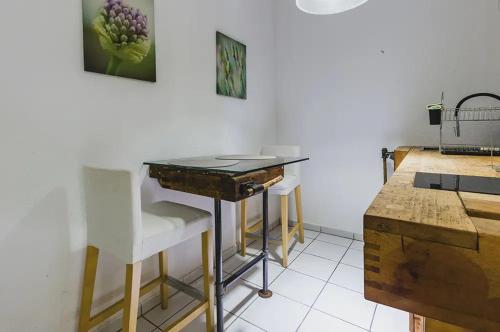 a kitchen with a table and some white chairs at Wismarer Heckflosse - ABC607 in Wismar