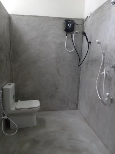 a bathroom with a toilet and a shower at Danu Surf House Hiriketiya in Dickwella