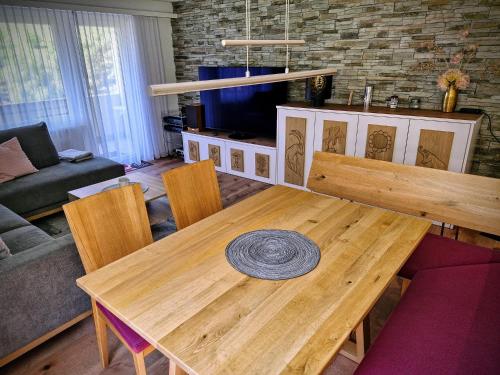 a wooden table and chairs in a living room at Ferienwohnung Valere B - it's magic gmbh in Leukerbad
