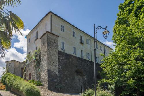 an old stone building with a street light in front of it at Renato Apartments Monforte D'alba in Monforte dʼAlba