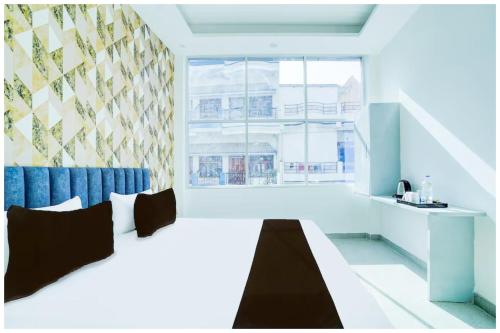 a bedroom with a bed and a large window at Hotel Siꓓꓓhi Vinayaka Inn Varanshi - Near Kashi Vishwanath Temple and Ganga Ghat with Fully Air Conditioned -Wi-fi #Restaurant #Parking - A Luxury Hotel In Varanasi in Varanasi