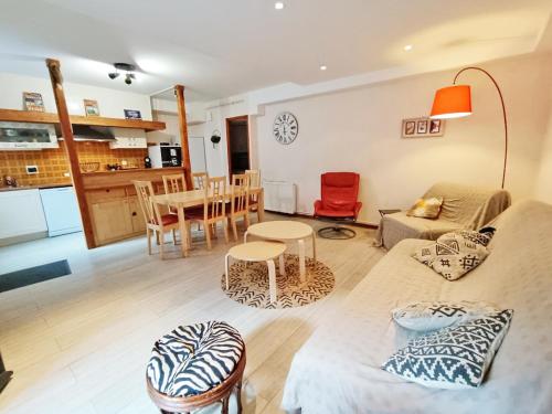 ein Wohnzimmer mit Sofa und Tisch in der Unterkunft Le Saint M, T3, wifi, parking, jardin, Saint Mamet in Saint-Mamet