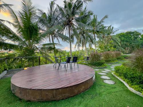two chairs sitting on a wooden circle in a garden at Gunung An Retreat in Ubud