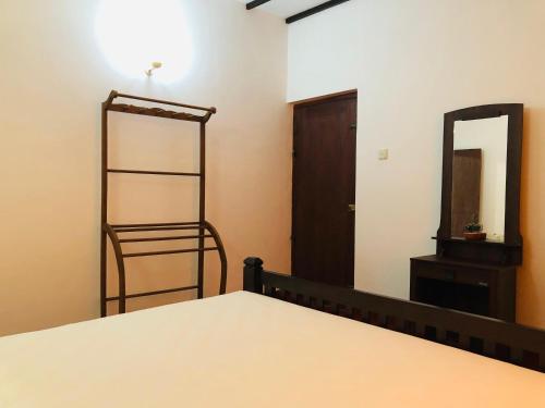 a bedroom with a bed and a mirror at Niskalanka Villa in Ahungalla