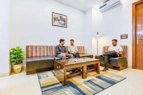 a group of three men sitting in a waiting room at FabHotel F-Aloyd Lajpat Nagar in New Delhi