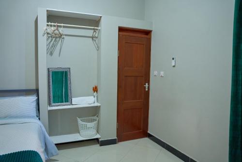 a bedroom with a bed and a wooden door at Heaven Homes - Salama Stay in Dar es Salaam