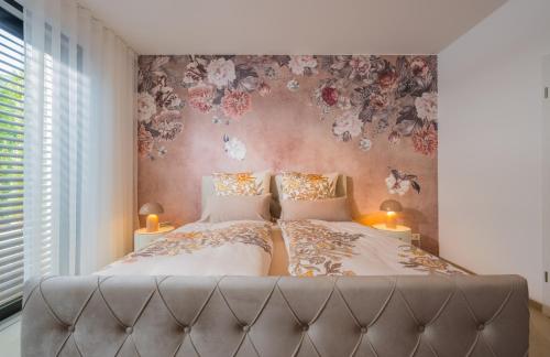 a bedroom with two beds with flowers on the wall at Palazzo Verde in Würzburg in Würzburg