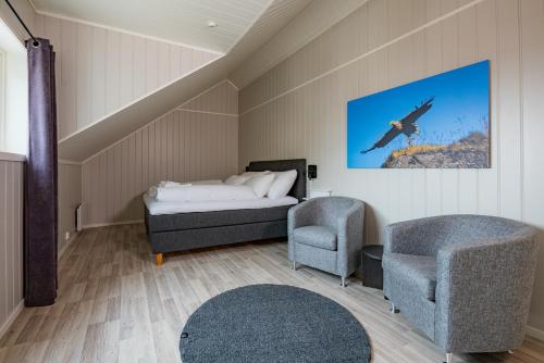 a bedroom with a bed and a chair at Ure Lodge in Sennesvik
