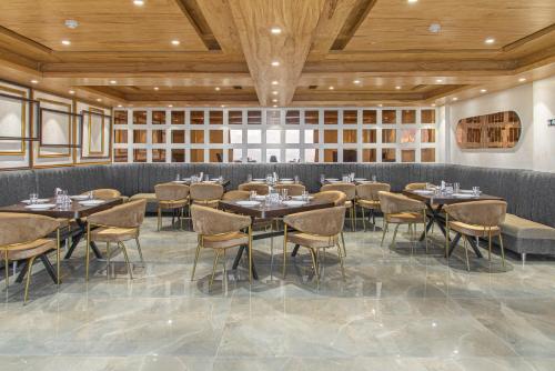 Un restaurante con mesas y sillas en una habitación. en The Ashirwad Kufri Resort By Pandora Hotels & Resorts, en Kūfrī