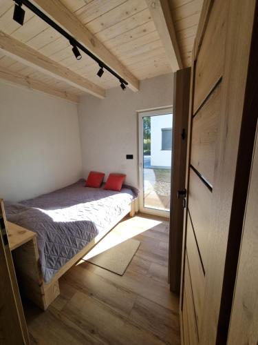 a small bedroom with a bed and a window at Przystań Lubie in Linowo
