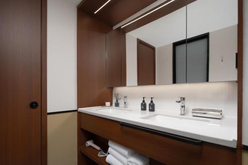 a bathroom with a sink and a mirror at Chengdu Chunxi Taikoo Li Su Beiting Serviced Apartment in Chengdu
