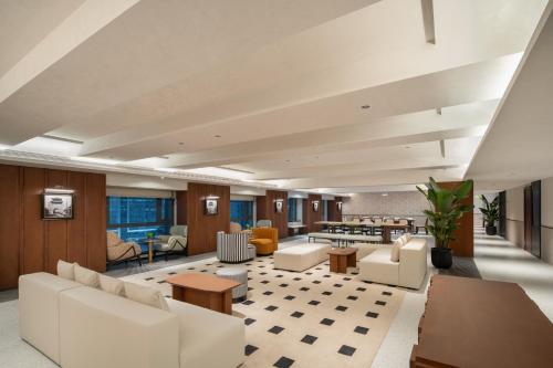 a large living room with white furniture and tables at Chengdu Chunxi Taikoo Li Su Beiting Serviced Apartment in Chengdu