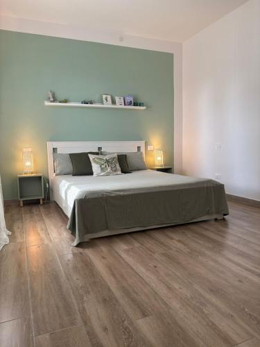 a bedroom with a large bed and wooden floors at B&B Il giardino segreto in Guarda Ferrarese