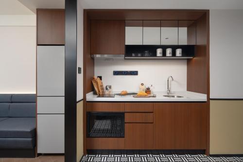 a kitchen with a sink and a stove at Chengdu Chunxi Taikoo Li Su Beiting Serviced Apartment in Chengdu