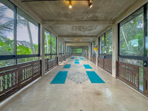 an empty hallway with blue mats on the floor at Gunung An Retreat in Ubud