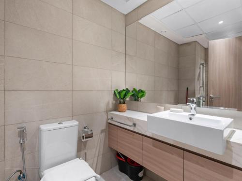 a bathroom with a white toilet and a sink at The Comfort Cove Studio in Azizi Riviera 44 in Dubai
