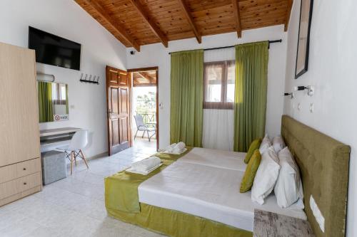 une chambre avec un grand lit avec un lavabo et un bureau dans l'établissement Blue Waves Corfu, à Kavos