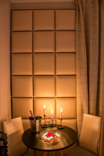 a table with two candles and a pizza on it at Alma Suites - Il Nido d'Amore in Livorno