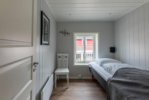 a bedroom with a bed and a window and a chair at Ure Lodge in Sennesvik