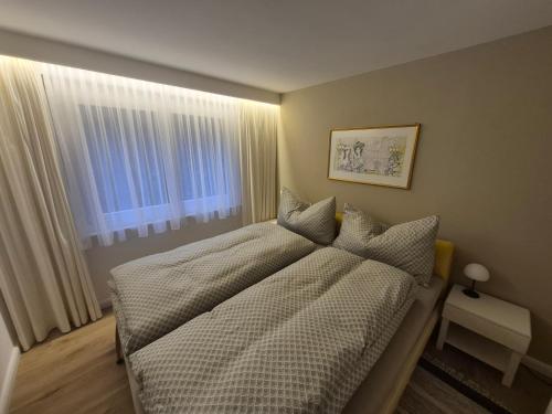 a bedroom with a bed and a window at Residence Edelweiss No Stress by Eva in Bellwald