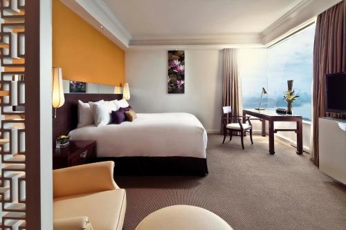 a hotel room with a large bed and a desk at Pan Pacific Hanoi in Hanoi