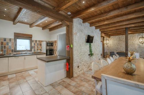 a kitchen and dining room with a wooden ceiling at La Antigua Taberna - Nieva in Nieva