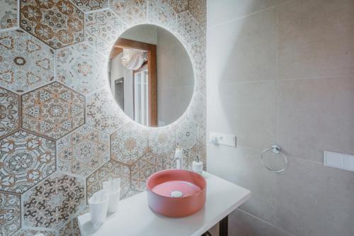 a bathroom with a round mirror and a sink at La Antigua Taberna - Nieva in Nieva