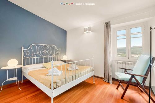 una camera da letto con un letto, una sedia e una finestra di Corte del Poeta, TerreMarine a Vezzano Ligure