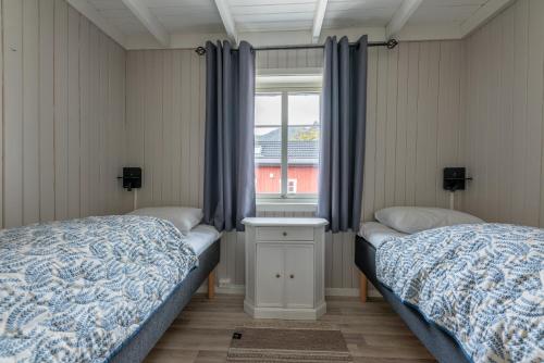 a bedroom with two twin beds and a window at Ure Lodge in Sennesvik