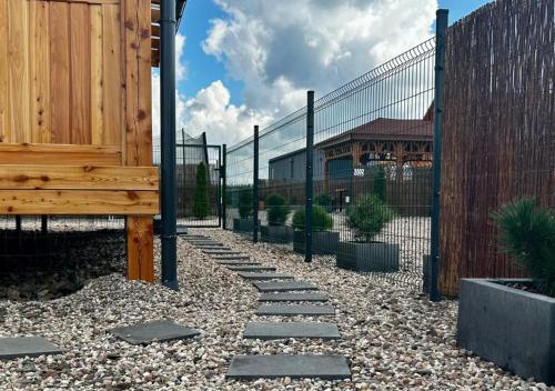 a garden with a fence and a stone pathway at Rajska polana Domki PREMIUM ,na odludziu z prywatną BALIĄ z jacuzzi i sauną ,Cisza,rowery elektryczne,góry,astroprzygoda,- Adršpach, Skalne Miasto, Zamek Książ,Andrzejówka,Karpacz, Śnieżka,Janskie Laznie,Pec in Mieroszów