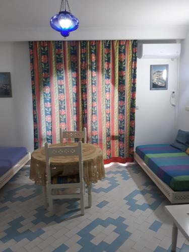 a room with a table and a bed and a couch at Tulip in Sousse