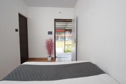 a bedroom with a bed and a door with a plant at Beach House Varkala by Palmyra in Varkala