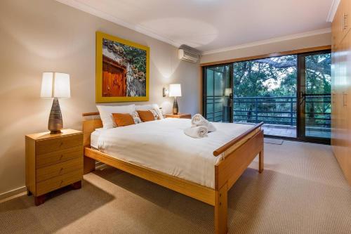 a bedroom with a large bed and a large window at Sea Vista - Beachside Resort-style Bliss in Broadwater