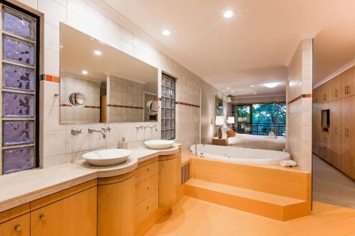 a large bathroom with two sinks and a tub at Sea Vista - Beachside Resort-style Bliss in Broadwater