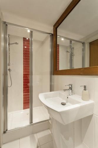 une salle de bain blanche avec lavabo et douche dans l'établissement Biolay 1, à Chamonix-Mont-Blanc
