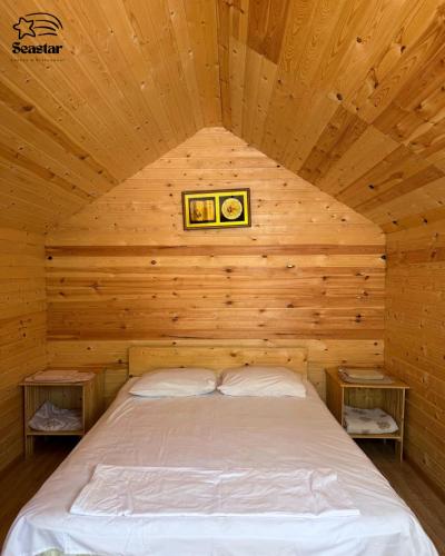 a bed in a room with a wooden ceiling at Sea Star in Sevan