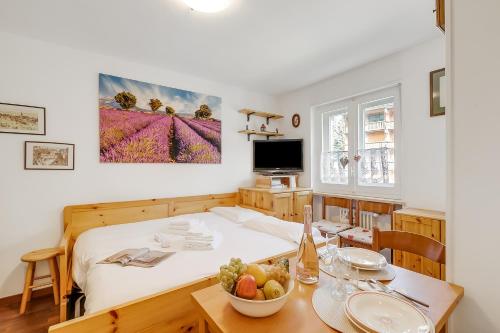 une chambre avec un lit et une table avec un bol de fruits dans l'établissement Hermitage Studio - close to ski pistes - Happy Rentals, à Borgata Sestriere