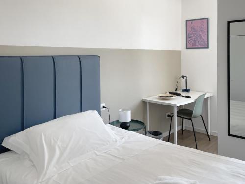 バーリにあるGuest House Biscardiの白いベッドと机のある寝室