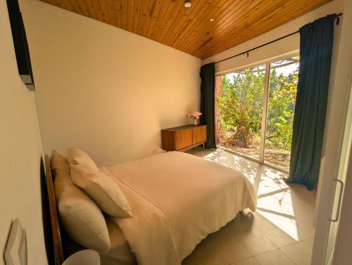 a bedroom with a bed and a large window at Quinta dos Sarilhos in Pedrógão Grande