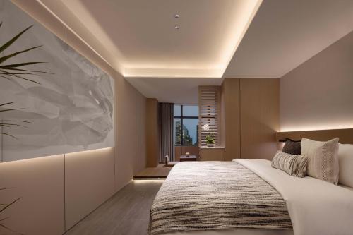 a bedroom with a large bed and a window at The S Heartland Hotel Chengdu（by Taikoo Li） in Chengdu